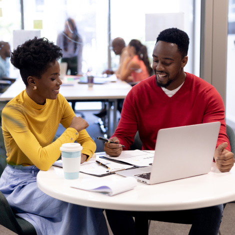 man and a woman sitting at a table looking at work